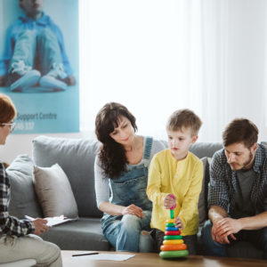 Parents in a therapy session with their autistic child.